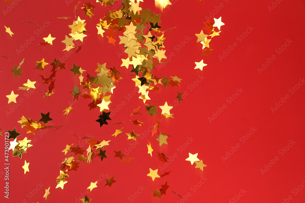 Flying confetti in shape of stars on red background Flying confetti in shape of stars on red background