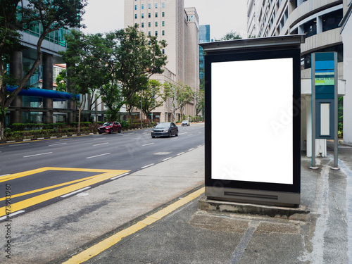 Vertical blank billboard ad mock up at a bus stop in the Central Business District of Singapore.