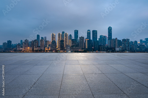Panoramic skyline and modern commercial buildings with empty square at night