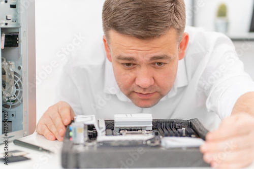 a man repairs motherboard. computer repair shop. professional services. 