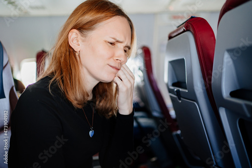 Fotografie a woman on an airplane has a toothache while flying on an airplane