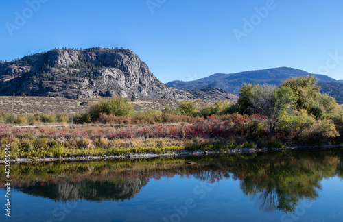 Mountains and trees reflecting in the canal in Osoyoos, BC