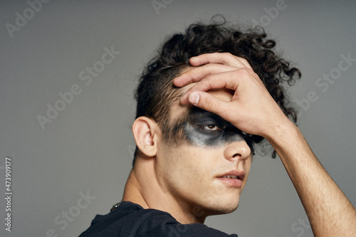 a man in a black mask Halloween costume ghost dark background