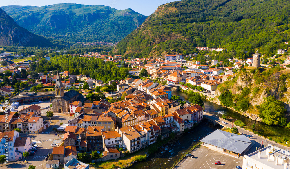 Fototapeta premium Panoramic aerial view of Tarascon-sur-Ariege commune surrounded by Pyrenees on sunny summer day, France