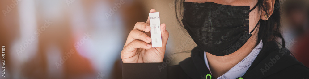 A female student in uniform carries an ATK tester for COVID-19 with negative results A female student in uniform carries an ATK tester for COVID-19 with negative results