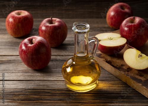 Apple vinegar in a glass container against a wooden background