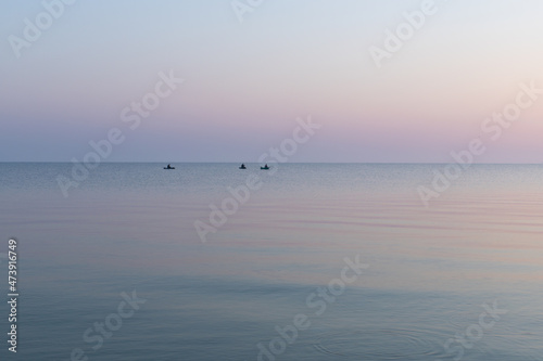 Sea at dawn with three fishing rubber boats  calm  Sea of Azov  Russia.