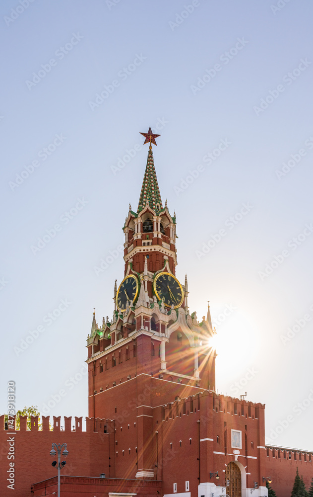 Spasskaya Tower of Moscow Kremlin on Red Square, Russia. Blue sky background with sunbeams