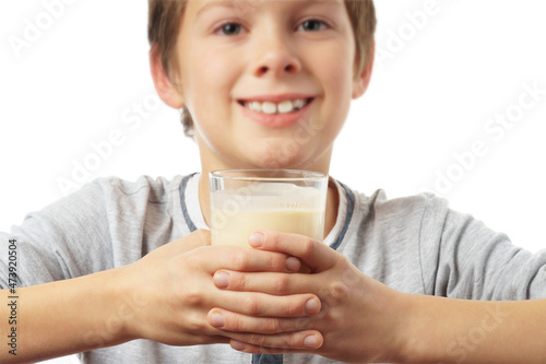 portrait of a happy caucasian boy with a glass of milk, isolated on white background.