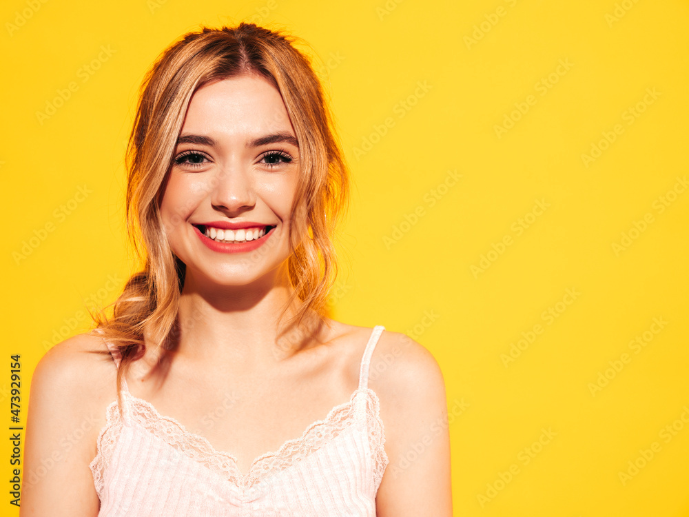 Fashion beauty portrait of young brunette woman with natural stylish  makeup and perfect clean skin. Sexy model with long curly hair posing in studio on yellow background