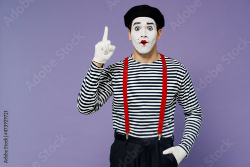 Tableau sur toile Surprised fun ecstatic young mime man with white face mask wears striped shirt beret pointing up on workspace area copy space mock up isolated on plain pastel light violet background studio portrait