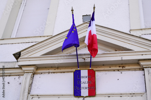 city hall facade france flag in town center on stone building with french text liberte egalite fraternite means freedom equality fraternity photo