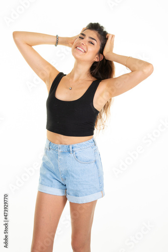 smiling slim girl brunette woman hand on hair in studio shot on white background