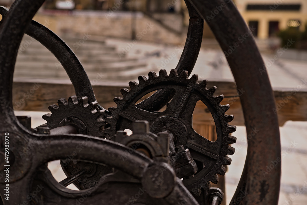 Fototapeta premium Stara przekładnia mechanizm starej , zabytkowej studni . Korba , studnia koła zębate , tryby. Old gear mechanism of an old, historic well. Crank, well, gears, modes. 