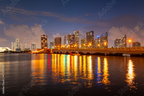 Miami, Florida cityscape skyline on Biscayne Bay. Panorama at dusk with urban skyscrapers and bridge over sea with reflection. © Volodymyr