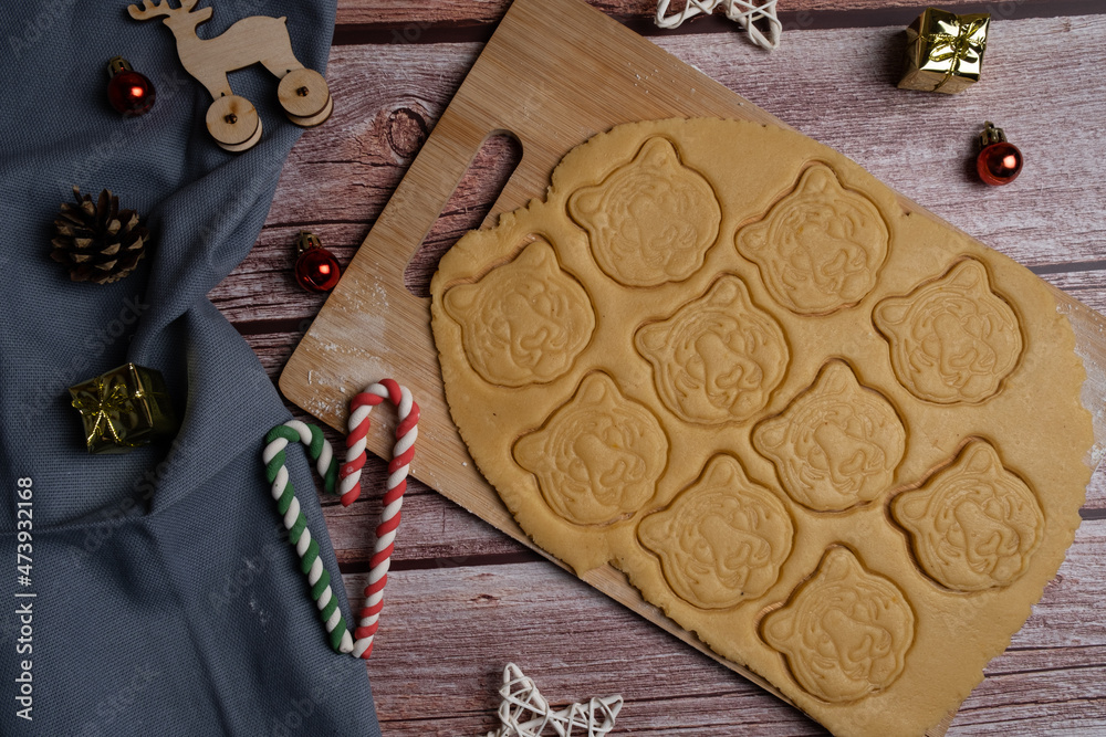 Cut out cookies in the form of a tiger's head from the dough for the new year