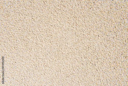 Uneven wall surface with decorative beige plaster