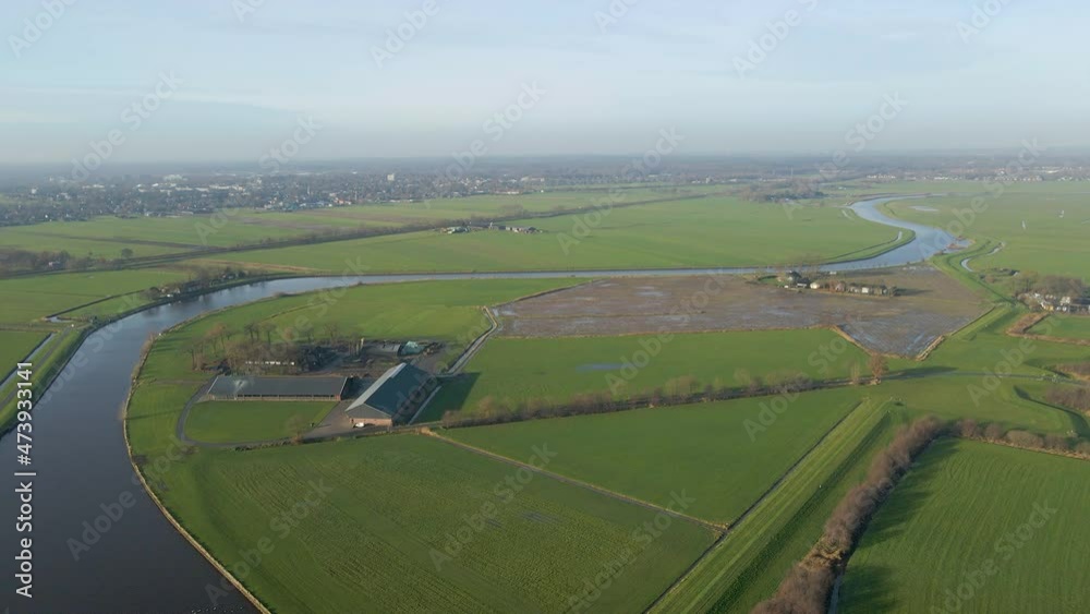 Aerial of a beautiful farm in rural meadows near a river in Dutch countryside Aerial of a beautiful farm in rural meadows near a river in Dutch countryside