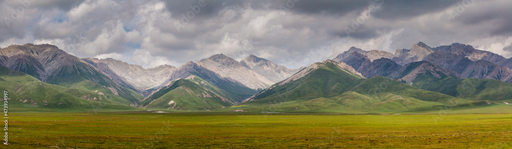 Panorama image of a mountain range under overcast sky in the Qi Lian mountains, Qinghai province, China
