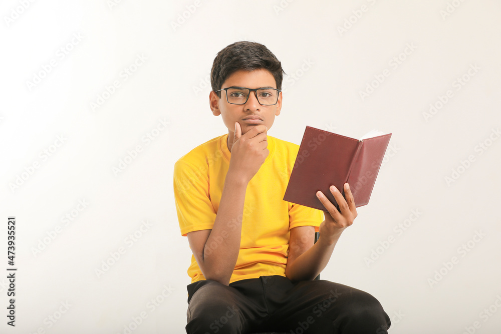 Indian boy holding diary in hand and thinking some idea on white background. Indian boy holding diary in hand and thinking some idea on white background.