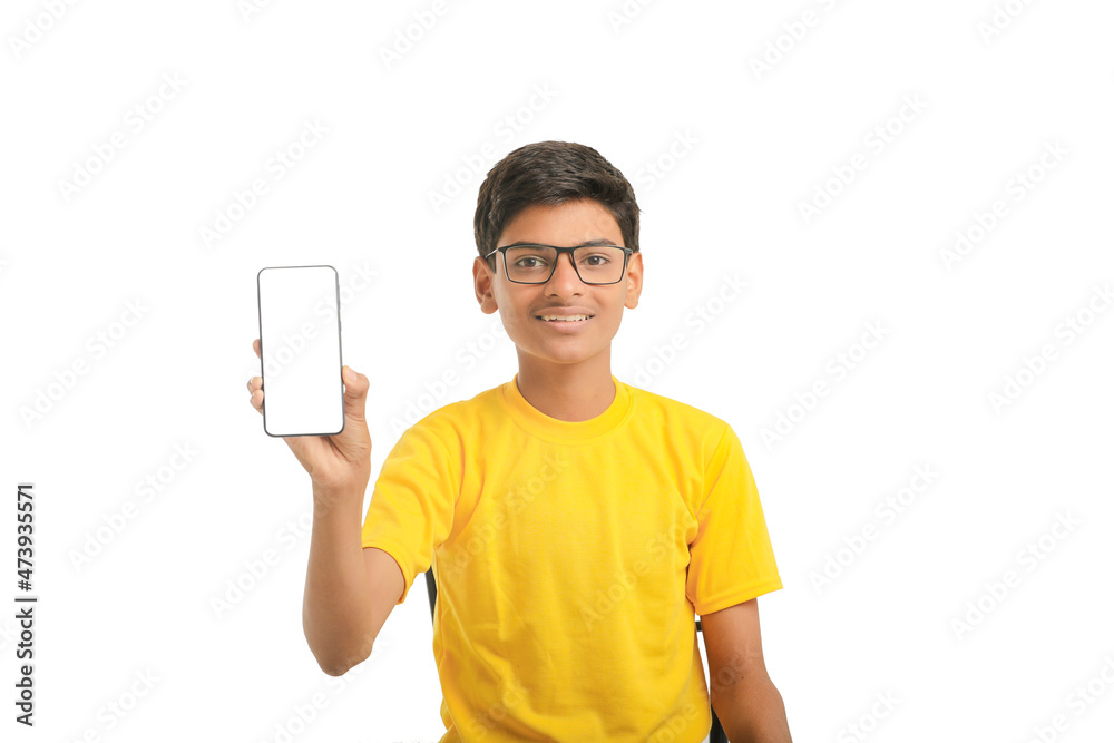 technology concept: Cute indian little school boy showing smartphone technology concept: Cute indian little school boy showing smartphone
