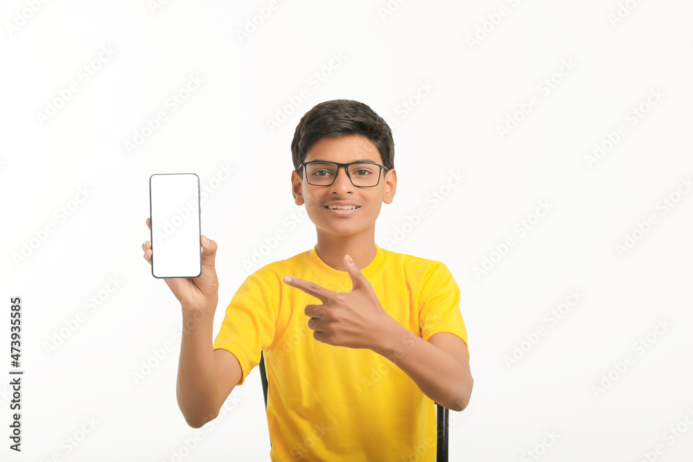 technology concept: Cute indian little school boy showing smartphone technology concept: Cute indian little school boy showing smartphone