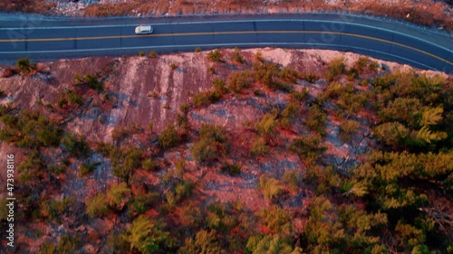 Aerial drone footage panning upward of the shawangunk mountains, a scenic highway, and the hudson valley in new york state during autumn at sunset. photo