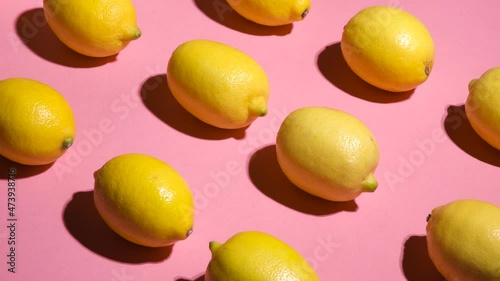 Stop motion. Movement of lemons on a pink background diagonally in different directions. Lemons on a pink background are moving in different directions. Abstract background.