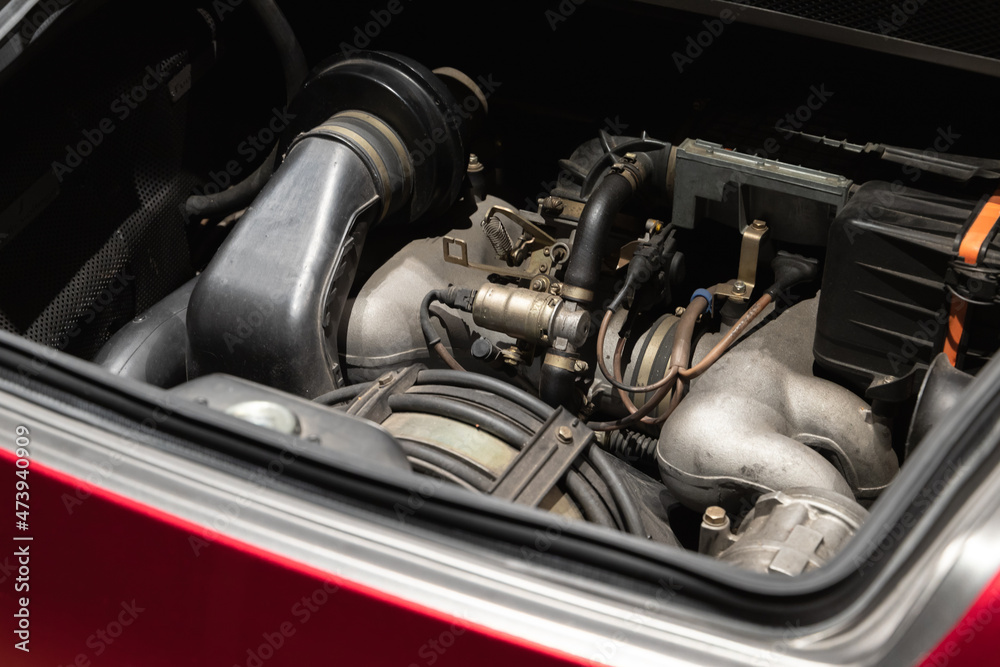 Sports car engine is under open hood Sports car engine is under open hood