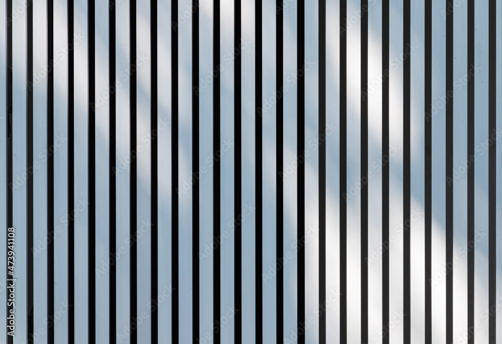 Soft shadows pattern is over white metal fence. Background texture Soft shadows pattern is over white metal fence. Background texture