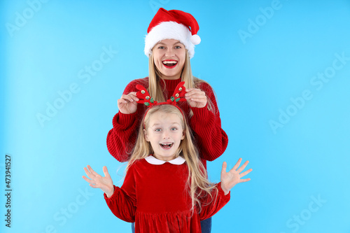 Mom and daughter on blue background, Christmas concept