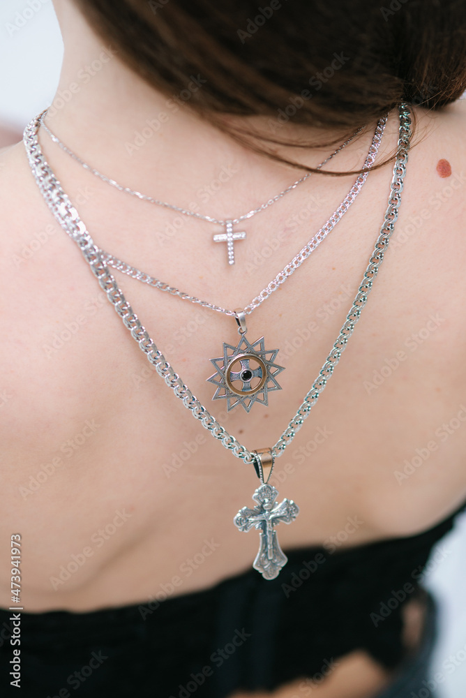 Trendy silver crosses and chain on a beautiful young girl. Beauty and fashion 
