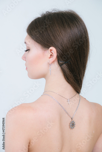 Trendy silver crosses and chain on a beautiful young girl. Beauty and fashion 
