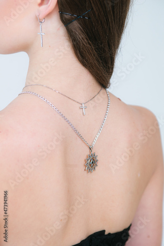 Trendy silver crosses and chain on a beautiful young girl. Beauty and fashion 
