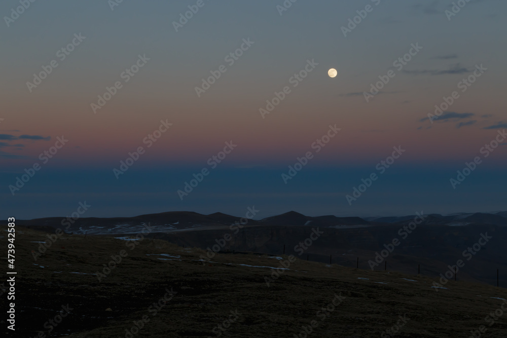 The moon in the setting cloudy winter sky The moon in the setting cloudy winter sky