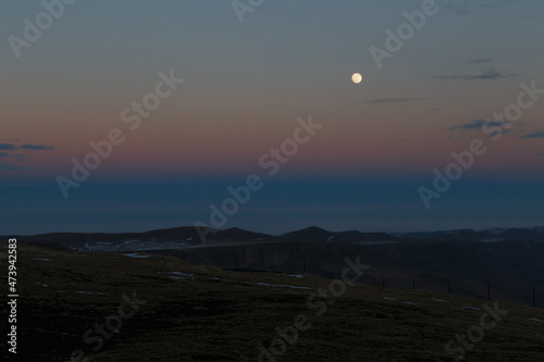 The moon in the setting cloudy winter sky