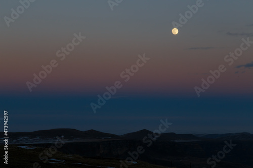 The moon in the setting cloudy winter sky