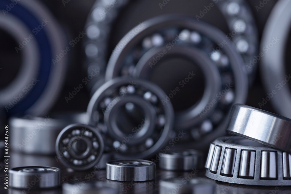 Steel bearing set. Ball radial and tapered plain bearings for mechanical engineering, heavy equipment and machine tools close-up. Spare parts in the form of round bearings of different sizes. Steel bearing set. Ball radial and tapered plain bearings for mechanical engineering, heavy equipment and machine tools close-up. Spare parts in the form of round bearings of different sizes.