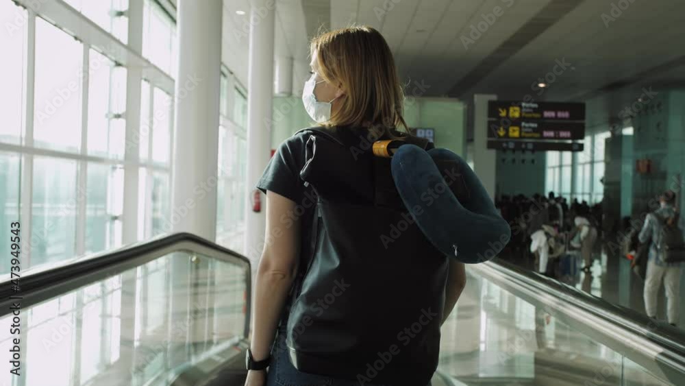 Young woman in medical mask with backpack in terminal airport. Traveling after vaccination. Young woman in medical mask with backpack in terminal airport. Traveling after vaccination.