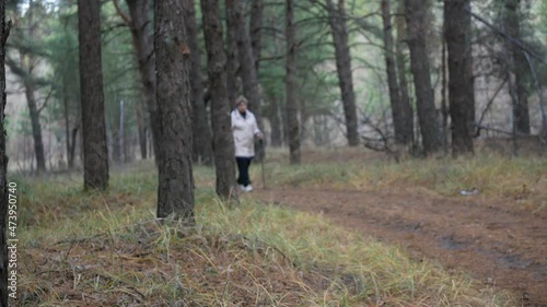 Woman, walking scandinavian outdoors. An active lifestyle in retirement, a hike in nature.