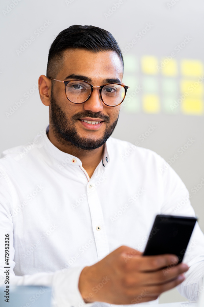 Handsome businessman with smart phone at office Handsome businessman with smart phone at office