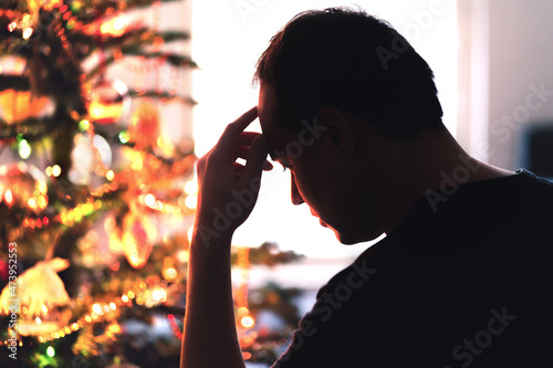 Sad on Christmas. Unhappy, lonely or tired man with stress, grief or depression. Family fight, loneliness, frustration or money problem on Xmas. Sick person with flu, pain and headache on holiday