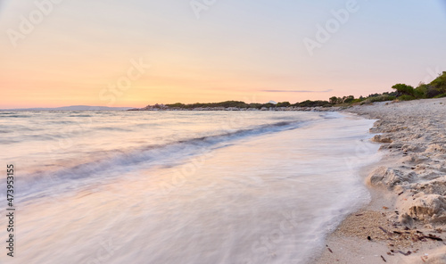 Karydi beach, Sithonia peninsula, Chalkidiki, Greece; scenic sunrise over sandy beach early in the morning with Mt. Athos in the background; long exposure shot of beautiful and peaceful beach at dawn © Dragan