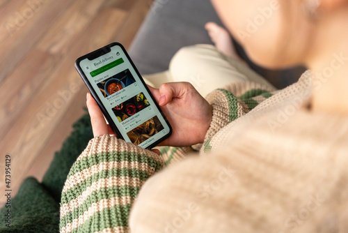 Young woman ordering food on mobile phone at home