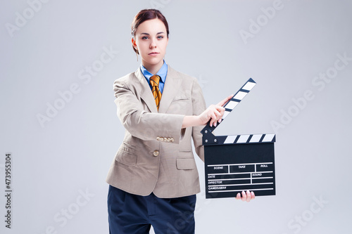 Portrait of Serious Caucasian Female Posing in Beige Blazer in Chair with Actioncut Indoors. photo
