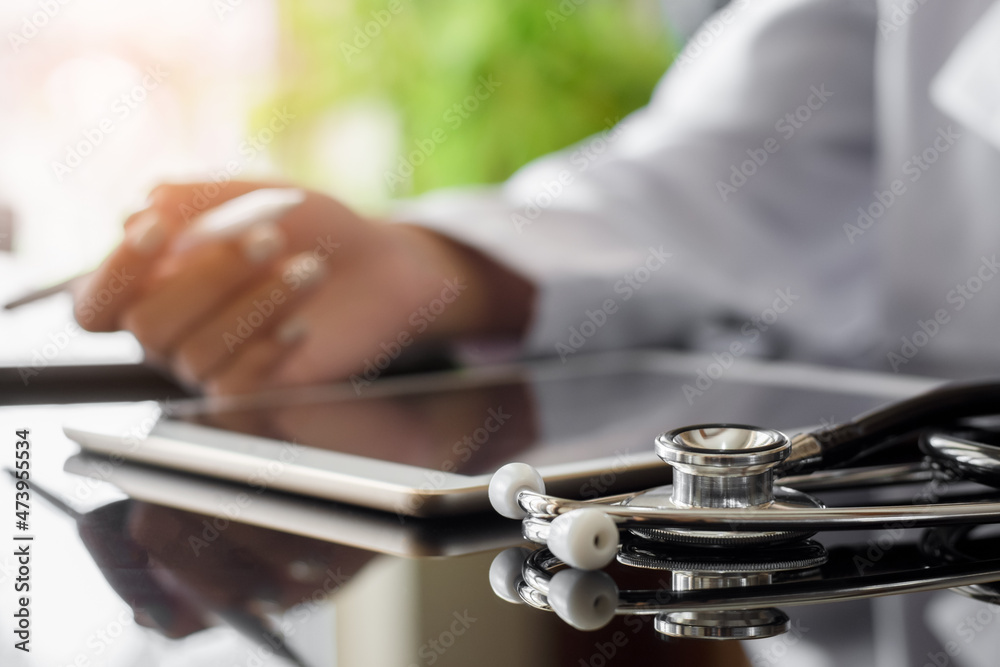 Female doctor using electronic pen work on digital tablet with stethoscope on the desk at office in clinic or hospital. Female doctor using electronic pen work on digital tablet with stethoscope on the desk at office in clinic or hospital.