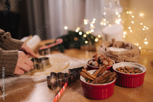 Woman making gingerbread at home. Female cutting cookies of gingerbread dough. Christmas and New Year traditions concept. Christmas bakery. Happy hollidays photo