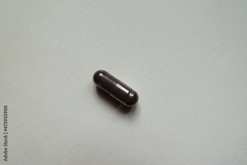 Naklejka premium One dark purple capsule of bilberry extract dietary supplement