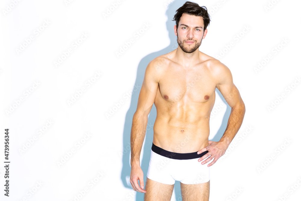 Tranquil and Sensual Caucasian Handsome Brunet Man Posing in Underware Against White Background Tranquil and Sensual Caucasian Handsome Brunet Man Posing in Underware Against White Background