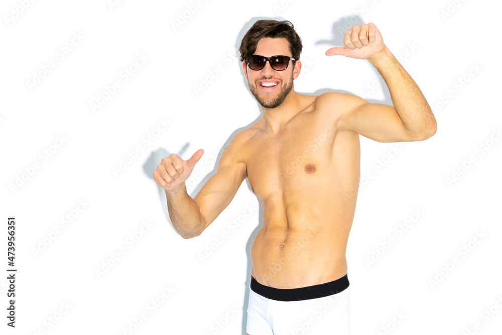 Expressive Caucasian Handsome Brunet Man in Sunglasses Gesturing With Both Hands While Posing in Underware Against White Background Expressive Caucasian Handsome Brunet Man in Sunglasses Gesturing With Both Hands While Posing in Underware Against White Background